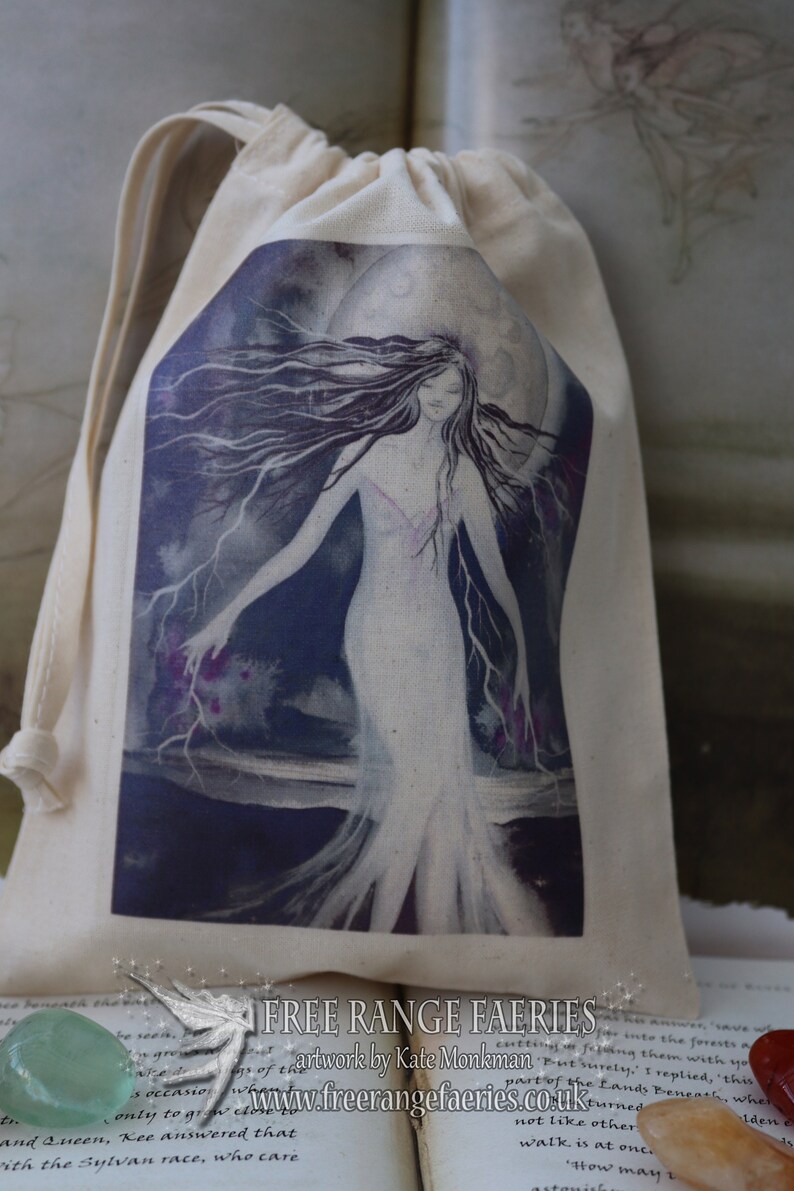 Puede incluir: Una bolsa de cord&oacute;n de algod&oacute;n blanco con una imagen impresa de una mujer con cabello largo y oscuro de pie frente a una luna llena. La mujer lleva un vestido blanco y tiene un d&eacute;bil resplandor rosado a su alrededor. El fondo es azul oscuro con nubes moradas y blancas. El texto "FREE RANGE FAERIES" est&aacute; impreso en la parte inferior de la bolsa. El texto "artwork by Kate Monkman" est&aacute; impreso debajo del texto de la bolsa. El texto "www.freerangefaeries.co.uk" est&aacute; impreso debajo del nombre del artista.