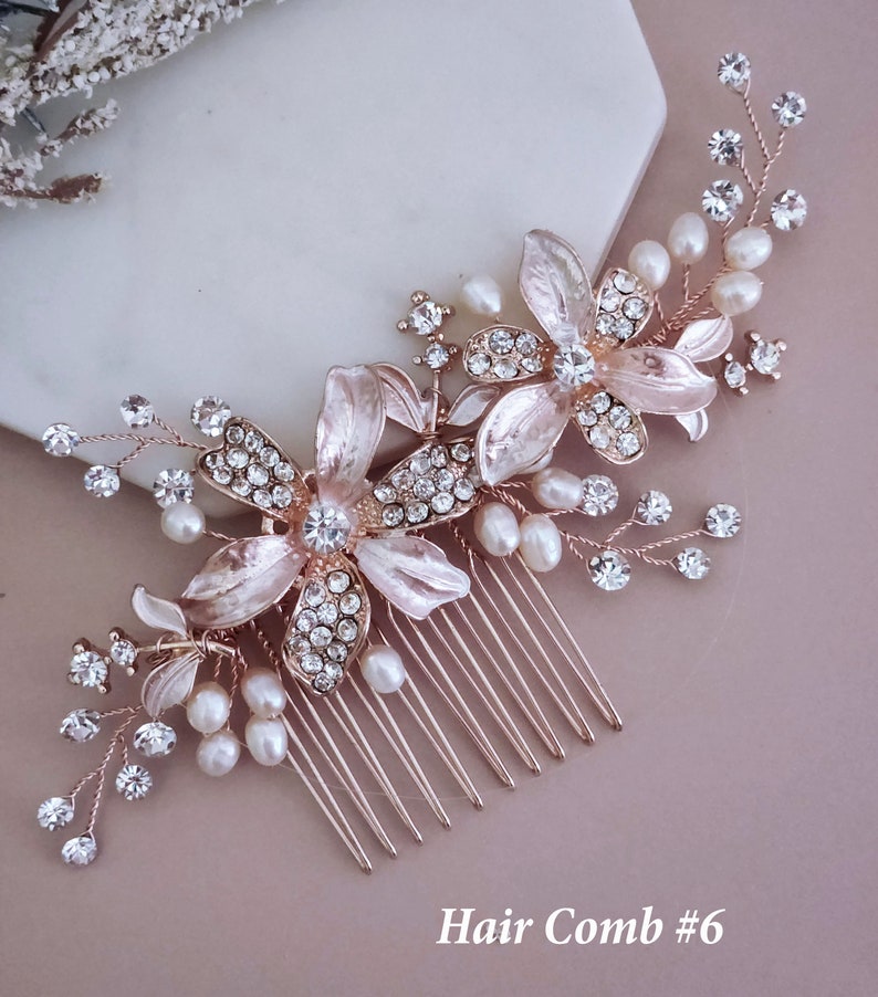 May include: A rose gold hair comb with floral and pearl detailing. The comb features two large flower designs with crystal centres and smaller crystals and pearls. The text "Hair Comb #6" is at the bottom.