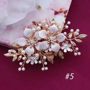 May include: A gold and silver floral hair comb with pearl accents. The comb features large, textured flowers, smaller blossoms, and delicate leaves. The number "5" is visible in the bottom right corner.