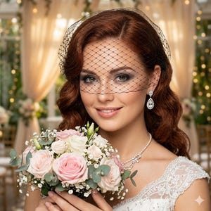 May include: A woman wearing a black net veil, pearl necklace, and diamond earrings, holding a bouquet of pink and white roses. The bouquet includes greenery and baby's breath. She is wearing a white lace dress.