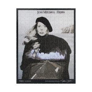 May include: Black and white embroidered puzzle of Joni Mitchell's album cover for "Hejira". The image features Joni Mitchell wearing a black beret and coat, with a road and clouds in the background. The text "Joni Mitchell Hejira" is at the top of the puzzle, and the text "Hejira - Joni Mitchell" is at the bottom left. The text "Hand embroidered artistry by Nadja Gordon" is at the bottom right.