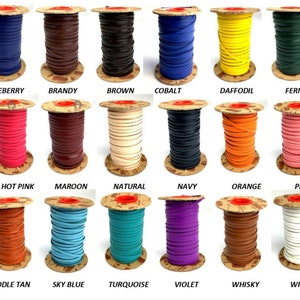 May include: A collection of 24 spools of leather cord in various colors, including black, blue, brown, green, grey, pink, purple, red, tan, white, and yellow. Each spool is labeled with the color name.