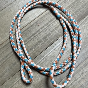 May include: A braided leather cord with a white, brown, and turquoise color pattern.