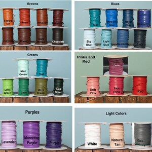May include: A collection of leather cord spools in various colors, including browns, blues, greens, pinks and reds, purples, and light colors. Each spool is labeled with the color name.