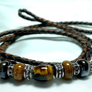 May include: A brown leather cord necklace with silver beads and tiger's eye stones.