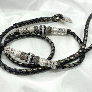 May include: A black leather braided leash with silver and black beads. The leash is approximately 40 inches long.