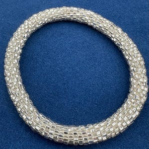 Pulsera rígida de ganchillo con cuentas de semillas y forro plateado estilo vintage