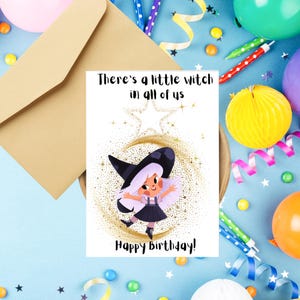 Puede incluir: Tarjeta de cumpleaños con una ilustración de bruja de dibujos animados. La tarjeta dice "There's a little witch in all of us" y "Happy Birthday!". La bruja tiene pelo blanco, un sombrero negro y un vestido negro. Decoraciones de fiesta.