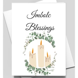 May include: A greeting card with the text "Imbolc Blessings" in black cursive font. The card features a wreath of green eucalyptus leaves with three white candles in the center.