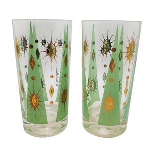 May include: Two clear drinking glasses with a mid-century modern design. The glasses feature a pattern of green stylized trees, diamonds, and starbursts in shades of gold and brown. The text "Gay Brown" is written on the side of each glass.