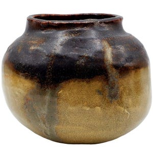 May include: A handcrafted ceramic vase with a rounded body and a slightly flared rim. The vase features a gradient of colors, transitioning from a dark brown at the top to a warm, golden-brown at the base. The texture appears rough and organic.