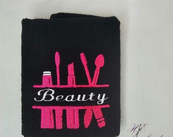 May include: Black towel with pink and white embroidery of makeup brushes and the word "Beauty".