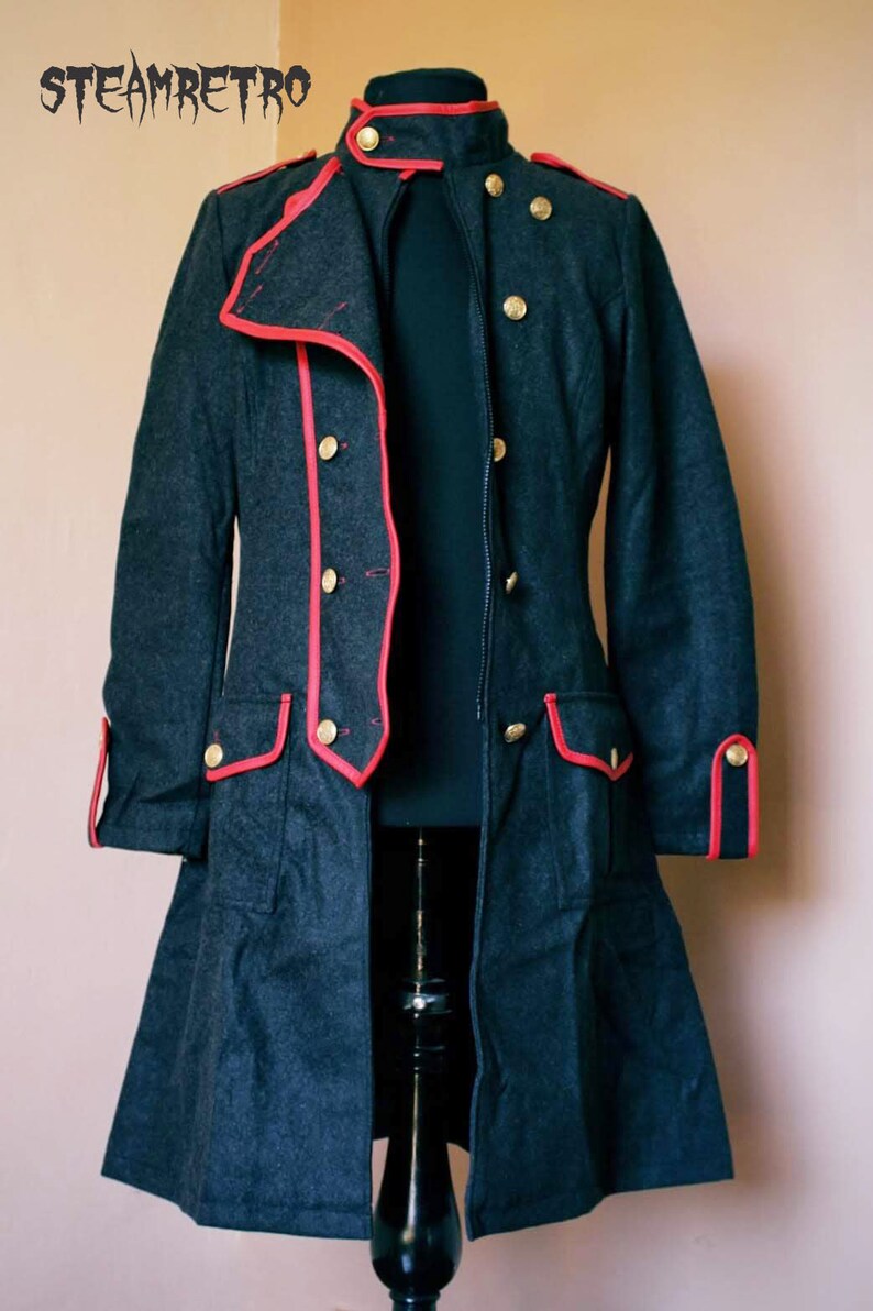 May include: A long, dark gray coat with a red trim and gold buttons. The coat has a stand-up collar and a zipper closure. The coat is on a mannequin.