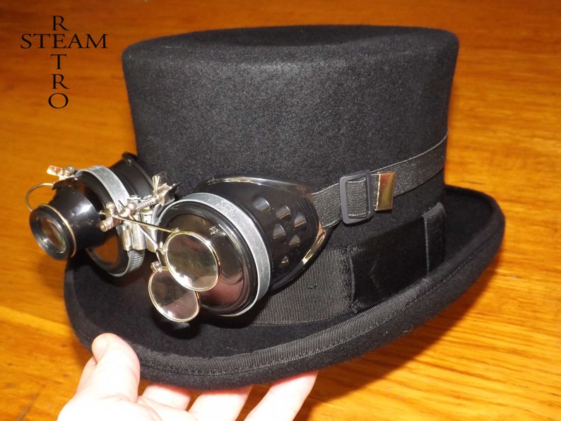 Peut inclure: Un chapeau haut de forme noir avec un bandeau &eacute;lastique noir et une paire de lunettes steampunk avec des verres grossissants.