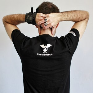 May include: Black t-shirt with a white graphic of a bat with a gas mask and the text "www.stemmetro.com".