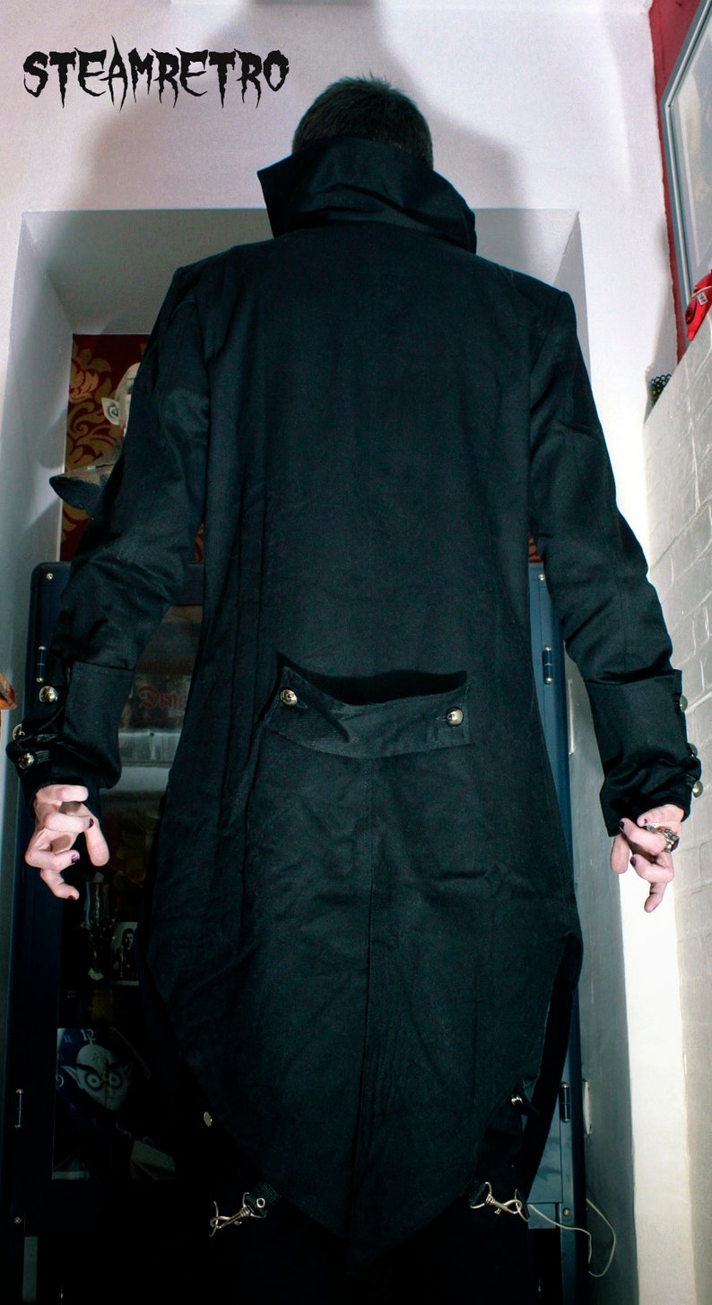 May include: A black long coat with a high collar and gold buttons. The coat has a long tail and is made of a thick fabric.