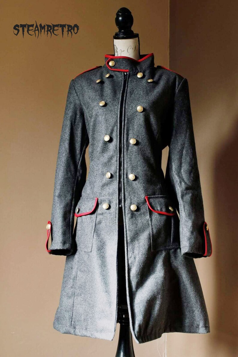May include: A gray wool coat with a red trim and gold buttons. The coat has a zipper closure and a stand-up collar.