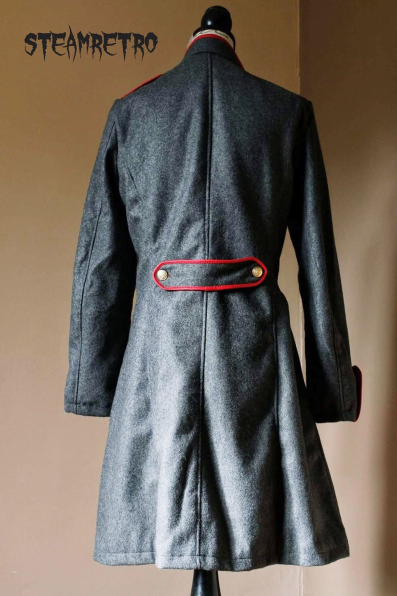 May include: A gray wool coat with a red trim and gold buttons. The coat has a long, flowing skirt and a high collar.