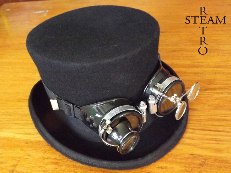 Peut inclure: Un chapeau haut de forme noir avec des lunettes de style steampunk noires et argent&eacute;es fix&eacute;es au bord. Les lunettes ont une loupe sur le c&ocirc;t&eacute;.