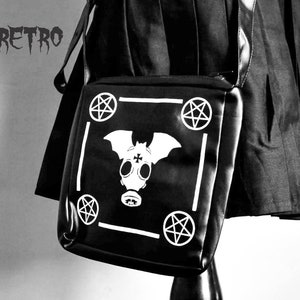 May include: Black shoulder bag with a white bat and pentagram design. The bag has a white border and the text "STEAMRETRO" is visible in the top left corner.