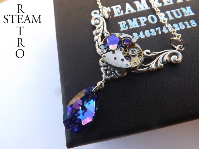 May include: A silver steampunk necklace with a purple crystal pendant and a vintage watch face with gears. The necklace is on a black background with the text "STEAM EMPORIUM 3468742518".