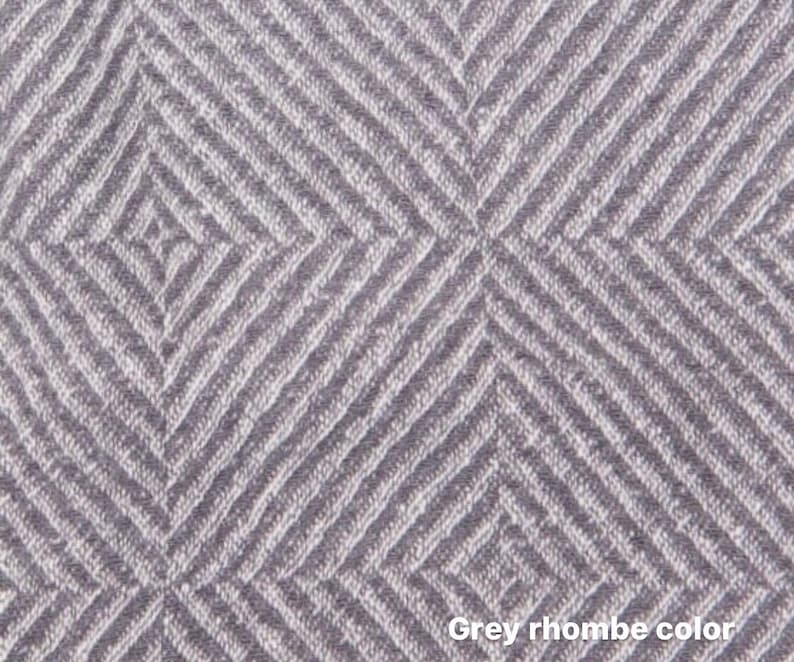 May include: A close-up of a grey fabric with a rhombus pattern. The fabric has a textured surface and a subtle sheen.