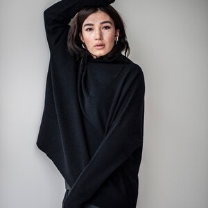 May include: A black turtleneck sweater with a loose fit and long sleeves. The sweater is made of a soft, comfortable material.