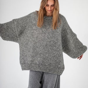 May include: A gray oversized knitted sweater with a relaxed fit and long sleeves.