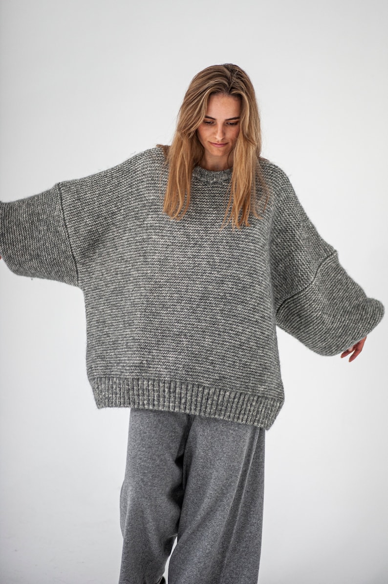 May include: A gray oversized knitted sweater with a relaxed fit and long sleeves.