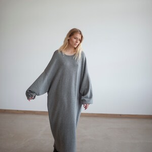 May include: A gray oversized sweater dress with long sleeves and a round neckline.