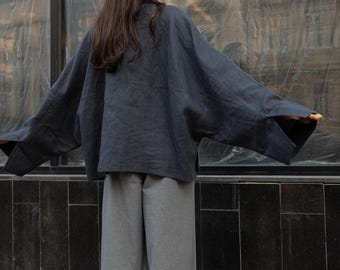 オーバーサイズの麻の着物風ジャケット、ゆったりとした黒のブラウス、ボヘミアン風カフタンスタイル