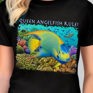 May include: Black t-shirt with a colorful illustration of a queen angelfish swimming in a coral reef. The text "Queen Angelfish Rule!" is printed on the shirt.