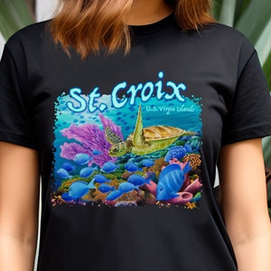May include: Black t-shirt with a colorful graphic of a sea turtle swimming in a coral reef with blue fish. The text "St. Croix U.S. Virgin Islands" is printed on the shirt.