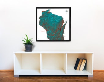 Puede incluir: Un mapa enmarcado de Wisconsin, con detalles en tonos turquesa y rojo, sobre un fondo blanco. El mapa está etiquetado como "Wisconsin". La obra de arte enmarcada en negro se exhibe sobre una estantería blanca, con una planta en maceta y libros.