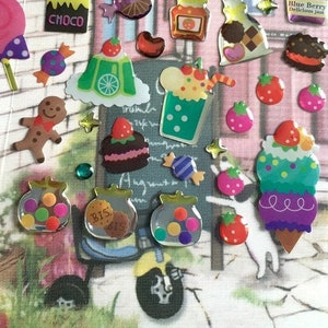 May include: A collection of colorful, shiny stickers featuring various sweet treats, including ice cream cones, candy, cupcakes, and gingerbread cookies. The stickers are perfect for decorating journals, planners, and other craft projects.