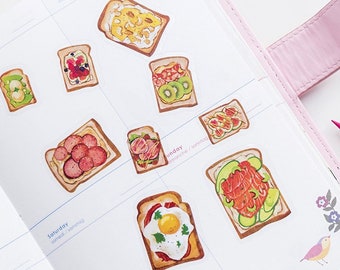May include: A set of 10 colourful illustrated stickers featuring different types of toast. The stickers are on a white background with a pink planner in the background.