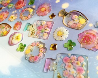 May include: A sheet of colorful floral stickers with a variety of designs, including roses, daisies, and wreaths. The stickers are transparent and have a glossy finish.