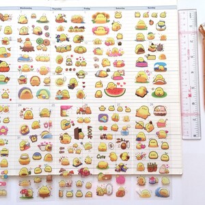 以下が含まれることがあります： 透明なステッカーシートに、さまざまなかわいい黄色いひよこのイラストが描かれています。ステッカーは白い背景にグリッド状に配置されています。各ステッカーには、スイカを持っている、帽子をかぶっている、バスケットに座っているなど、さまざまなポーズや活動をしているひよこが描かれています。