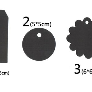 May include: Three black paper gift tags with different shapes and sizes. The first tag is a rectangle with rounded corners, measuring 3.5 inches by 8 inches. The second tag is a circle, measuring 5 inches in diameter. The third tag is a scalloped circle, measuring 6 inches in diameter.
