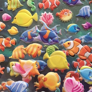 Puede incluir: Una colecci&oacute;n de pegatinas de espuma 3D de colores que representan varias criaturas marinas, incluidos peces, caballitos de mar, estrellas de mar y una tortuga. Las pegatinas son perfectas para agregar un toque caprichoso a cualquier proyecto.