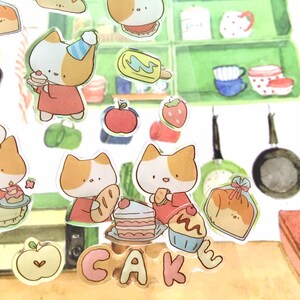 K&ouml;nnte beinhalten: Ein Set bunter Sticker mit niedlichen Katzen, Kuchen und anderen s&uuml;&szlig;en Leckereien. Die Sticker sind perfekt, um Ihrem Planer, Tagebuch oder Sammelalbum einen Hauch von Verspieltheit zu verleihen.