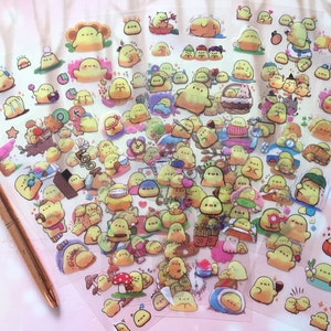 以下が含まれることがあります： 様々なかわいい黄色のひよこのイラストが描かれた透明なステッカーシートです。ステッカーには、コーヒーカップを持っている、帽子をかぶっている、キノコに座っているなど、さまざまなポーズ、アクティビティ、アクセサリーが含まれています。ステッカーは、プランナー、ジャーナル、その他のクラフトプロジェクトに遊び心を加えるのに最適です。