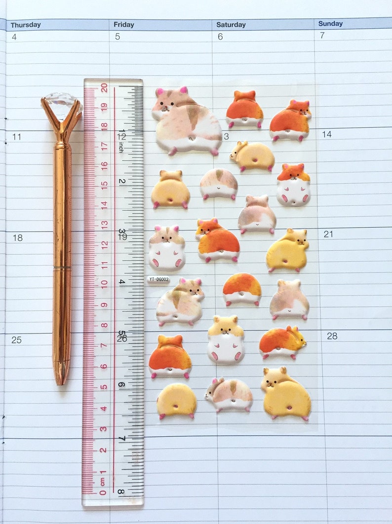 May include: A sheet of colorful hamster stickers with a ruler and a gold pen. The stickers feature hamsters in various poses, including sitting, standing, and running. The stickers are perfect for adding a touch of whimsy to planners, journals, and other paper goods.