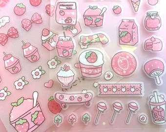Può includere: Un foglio di adesivi rosa e bianchi con vari disegni a tema fragola, tra cui fragole, fiocchi, bicchieri di yogurt, coni gelato e uno skateboard. Gli adesivi sono perfetti per aggiungere un tocco di dolcezza a planner, diari e altri progetti di artigianato.