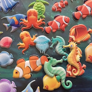 Puede incluir: Una colecci&oacute;n de pegatinas de espuma de colores que representan varias criaturas marinas, incluyendo peces, caballitos de mar, medusas y un pulpo. Las pegatinas son perfectas para a&ntilde;adir un toque de fantas&iacute;a a cualquier proyecto.