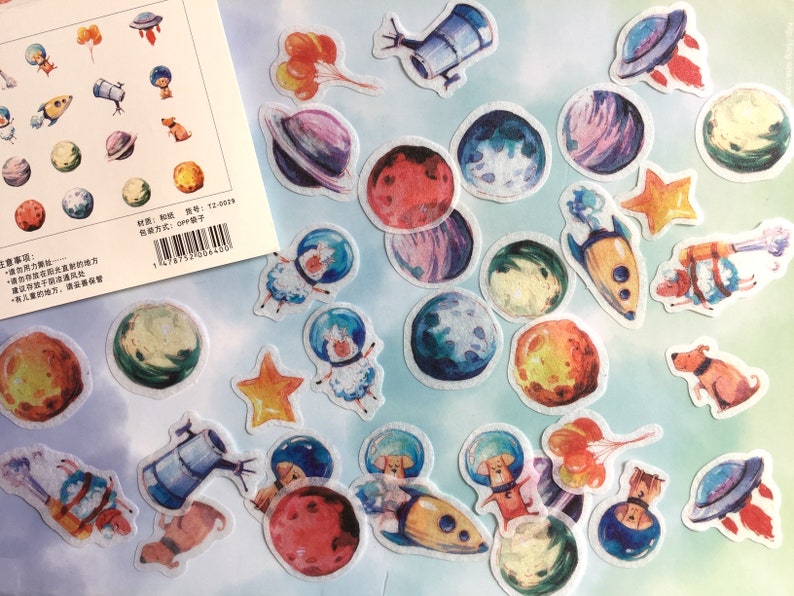 Puede incluir: Una hoja de pegatinas coloridas con ilustraciones de tem&aacute;tica espacial. Las pegatinas incluyen planetas, estrellas, cohetes, naves espaciales y astronautas. Las pegatinas son perfectas para a&ntilde;adir un toque de fantas&iacute;a a los diarios, planificadores y otros proyectos creativos.