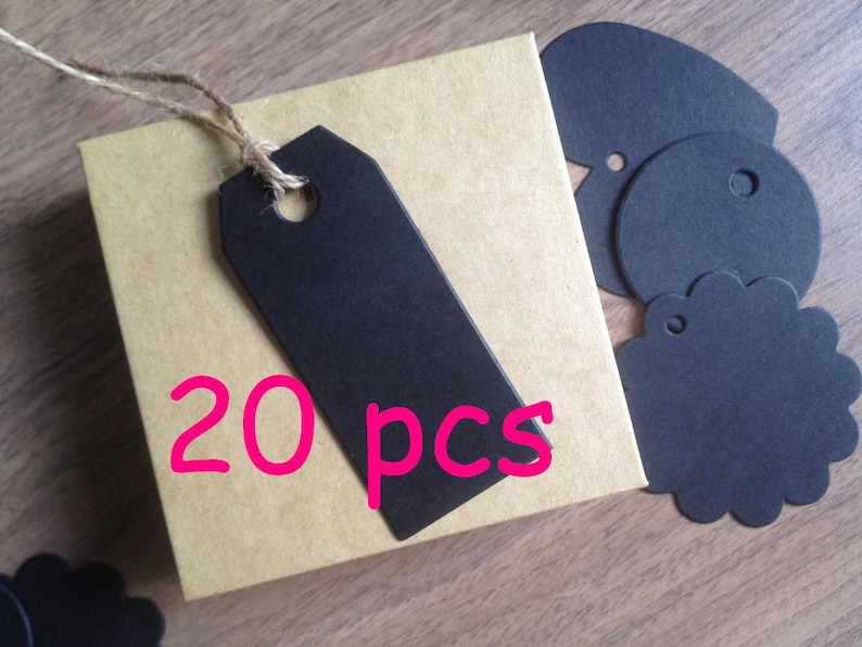 May include: A set of 20 black paper gift tags with a hole for string or ribbon. The tags are in a brown box with the text "20 pcs" printed on the front.
