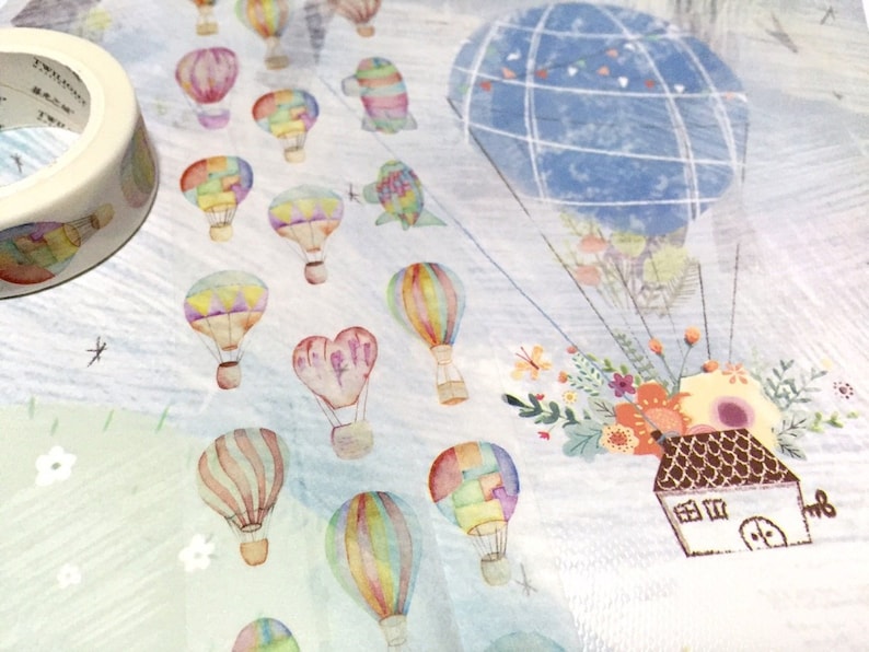 May include: A white background with a blue and white checkered hot air balloon, a brown house with a keyhole, and many colorful hot air balloons flying in the sky.