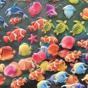 Puede incluir: Una colecci&oacute;n de pegatinas de espuma 3D de colores que representan varias criaturas marinas, incluidos peces payaso, caballitos de mar, estrellas de mar, conchas marinas y tortugas. Las pegatinas son perfectas para agregar un toque de fantas&iacute;a a las manualidades, los diarios o cualquier otro proyecto.
