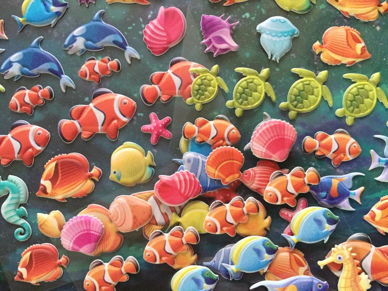 Puede incluir: Una colecci&oacute;n de pegatinas de espuma 3D de colores que representan varias criaturas marinas, incluidos peces payaso, caballitos de mar, estrellas de mar, conchas marinas y tortugas. Las pegatinas son perfectas para agregar un toque de fantas&iacute;a a las manualidades, los diarios o cualquier otro proyecto.